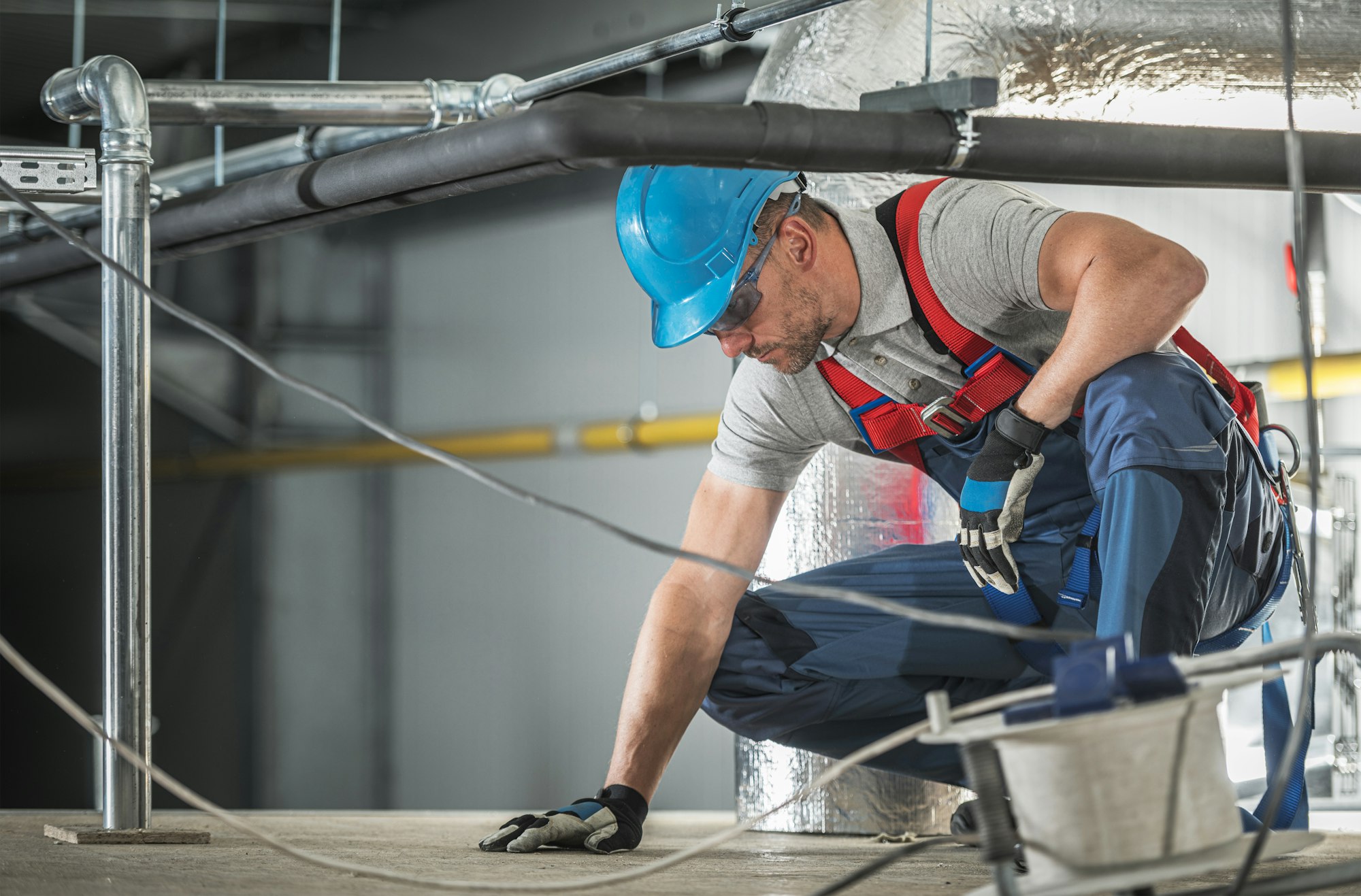 Caucasian HVAC Worker Wearing Safety Harness at Work