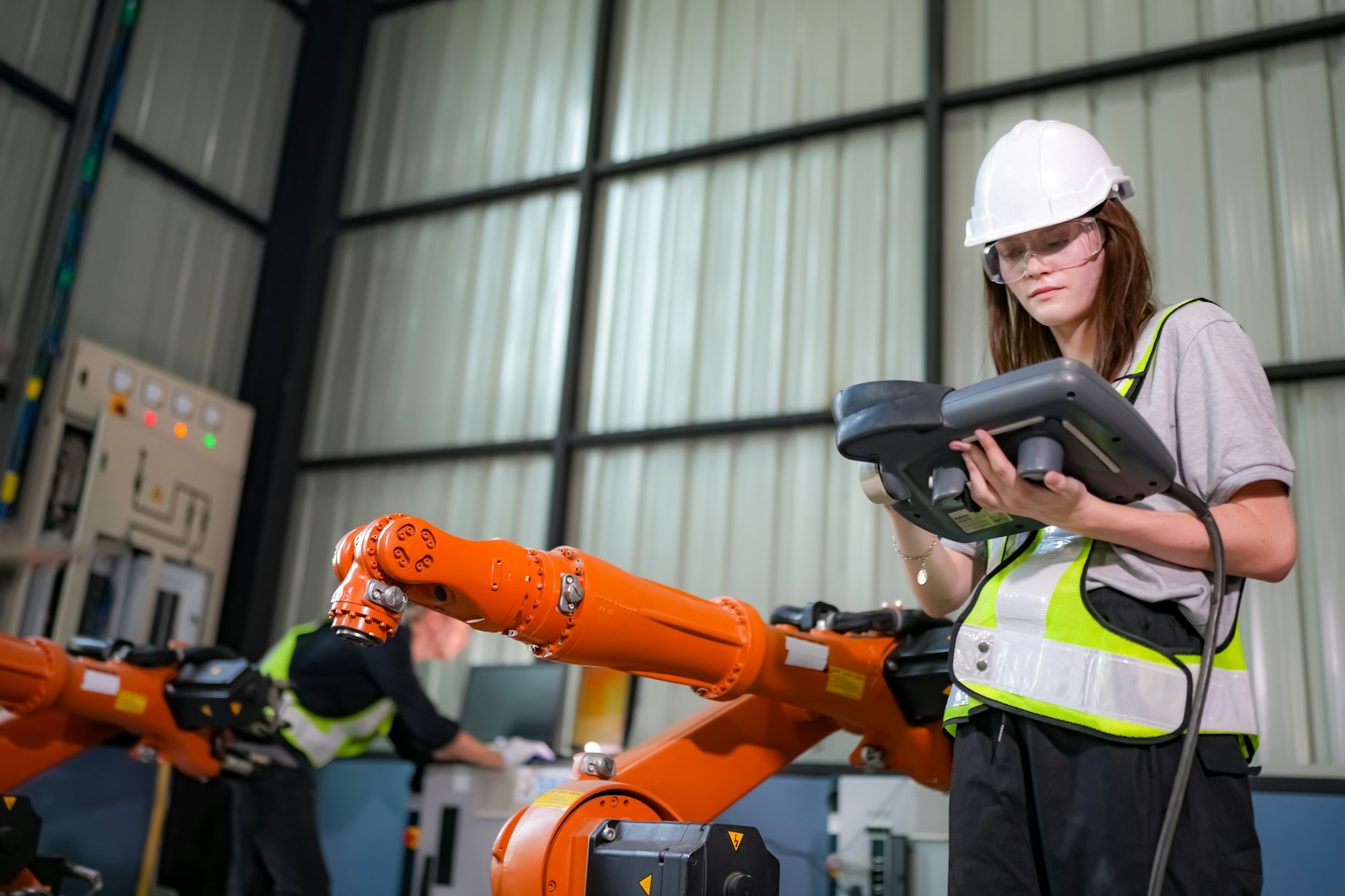 Engineer testing a robotic production simulator in robotics research facility